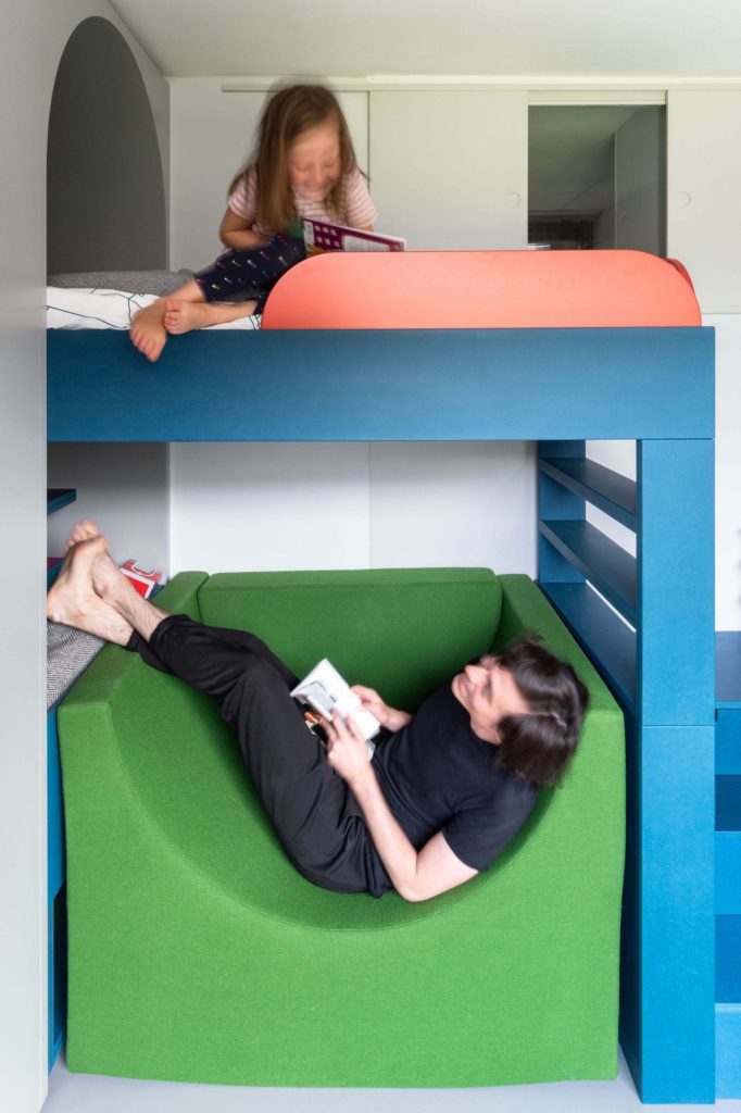Un lit loft à deux places avec une chaise verte en dessous