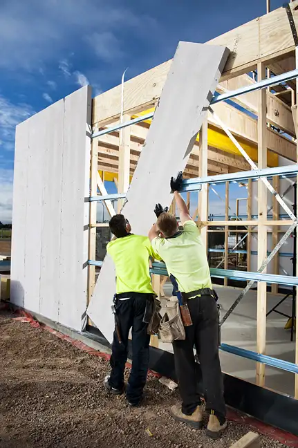 Photographie dun panneau AAC en cours dinstallation sur un mur dune maison en construction